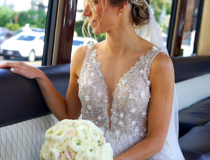 Capture the enchantment of your special day with our premium limousine services in Boston. Pictured is a radiant bride adorned in a sparkling wedding gown, holding a delicate white bouquet, seated comfortably within our spacious and opulent party bus. The interior's sleek design, paired with the warm natural light, creates an intimate haven for this unforgettable moment.